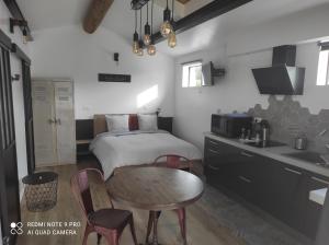 Cet appartement comprend une chambre avec un lit et une table ainsi qu'une cuisine. dans l'établissement L'atelier de Guytou et Spa, à Cheval-Blanc