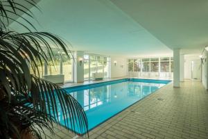 a swimming pool in a house with a tile floor at Fewo Luzia in Schönwald