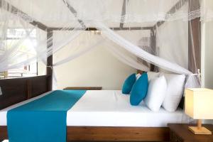 a bedroom with a bed with blue and white pillows at The Blue Haze Weligama in Weligama