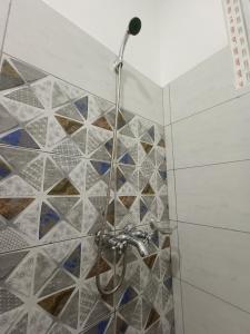 a shower in a bathroom with mosaic tiles at City Centre in Mombasa