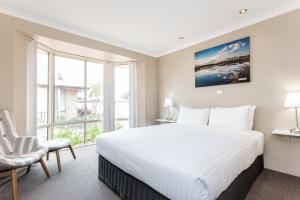 a bedroom with a bed and a large window at Quality Apartments Banksia Albany in Albany
