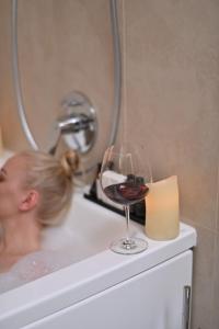 a woman laying in a bath tub next to a bath tub sink at Hotel Panorama De Luxe in Odesa