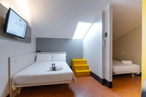 a room with a bed and a tv and a bed and a room with at B&B Hotel Trieste in Trieste