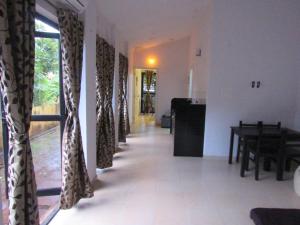 - un couloir avec des rideaux dans une chambre avec une table dans l'établissement Retreat Holiday Homes, Twin Chalets at Sparsh Resorts and Chalets, Karjat, à Karjat