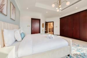 A bed or beds in a room at Breath-taking 6BR Villa in Frond E Palm Jumeirah by Deluxe Holiday Homes