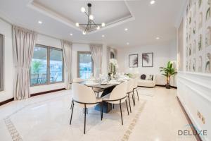 a dining room with a table and chairs at Breath-taking 5BR Villa with Assistants Room and Private Pool in Frond E Palm Jumeirah by Deluxe Holiday Homes in Dubai