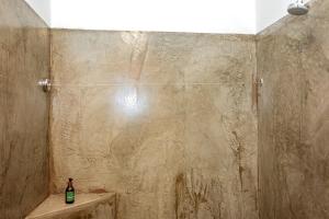 Duwisib的住宿－At Kronenhof Lodge，带淋浴的浴室,配有1瓶位于水槽的瓶装水