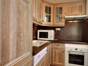 a kitchen with wooden cabinets and a sink and a microwave at Appartement La Plagne, 2 pièces, 5 personnes - FR-1-455-78 in La Plagne