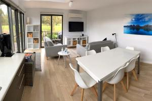 un salon avec une table et des chaises blanches dans l'établissement Fairways 1, à Coles Bay 13 autres photos