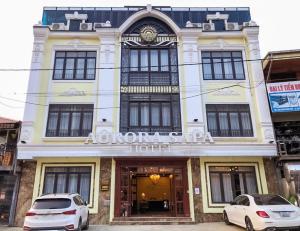 dos coches estacionados frente a un edificio en Aurora SaPa Hotel, en Sa Pa