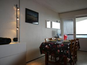 Cette chambre comprend une cuisine et une table avec des chaises. dans l'établissement Studio Chamrousse, 1 pièce, 4 personnes - FR-1-549-64, à Chamrousse