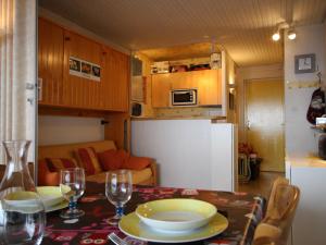 una cocina con una mesa con platos y copas de vino en Studio Chamrousse, 1 pièce, 4 personnes - FR-1-549-64 en Chamrousse