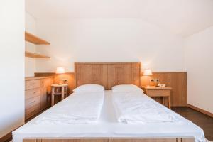 1 dormitorio con 1 cama grande y armarios de madera en Hotel Kronplatz, en Valdaora