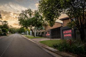 an empty street with a sign that reads make mumps at Mereke Manor in Centurion