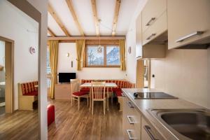 a kitchen and dining room with a table and chairs at Runcac Apt Gomina in San Vigilio Di Marebbe