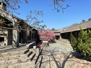 a courtyard of a building with a pink tree at 7Shang长城大宅 in Huairou