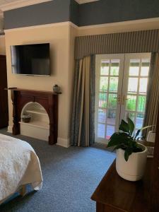 a bedroom with a bed and a fireplace with a television at Avon Terrace Guest House in York
