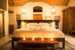 a bedroom with a large bed with candles on it at Klaserie Drift in Klaserie Private Nature Reserve