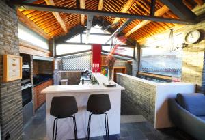 een keuken met een bar en 2 krukken bij 7Shang长城大宅 in Huairou