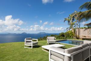 三河市JOULOUKA的一个带两把椅子的庭院、一个游泳池和大海