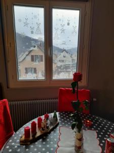 a table with christmas decorations on it with a window at Gîte les chiwawas d'Alsace in Kaysersberg