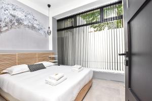 een slaapkamer met een wit bed en een groot raam bij CMG - Nation Charonne G in Parijs