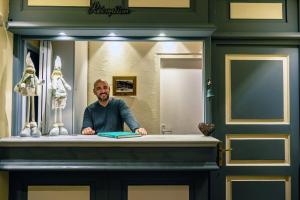 un homme assis au comptoir devant un miroir dans l'établissement Hôtel L'Arbina, à Tignes
