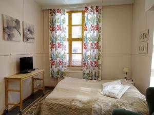 Kovero的住宿－Koveron Majatalo，一间卧室配有一张床、一张书桌和一个窗户。