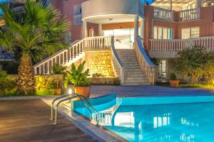 a swimming pool in front of a house at Belvedere Gerakas Luxury Suites in Vasilikos