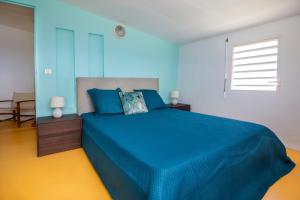 - une chambre bleue avec un lit et une couverture bleue dans l'établissement JOULOUKA, à Trois-Rivières