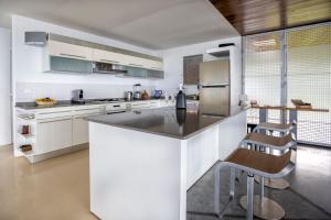 a large white kitchen with a counter and chairs at JOULOUKA in Trois-Rivières
