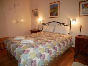 a bedroom with a bed with a colorful comforter at Apollo-Vacances Pirinenca in Soldeu