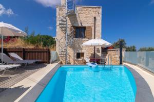 a swimming pool with a villa in the background at Marni in Gállos