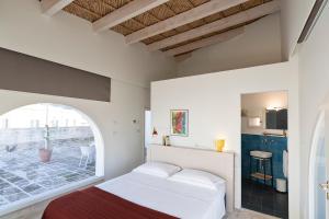 a bedroom with a bed and an arched window at Distilia Dimora Salentina in San Cesario di Lecce +79 photos