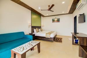 a living room with a bed and a blue couch at Mountain Breeze Resort, Mahabaleshwar in Mahabaleshwar