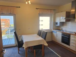 a kitchen with a table and chairs and a kitchen with a balcony at Landhaus Braband Ferienwohnungen - Cuxhavener Straße 96 in Cuxhaven +15 photos