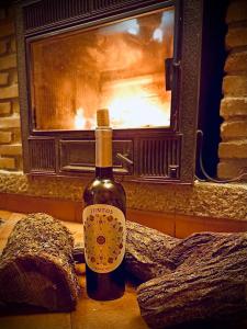 a bottle of wine sitting on a table in front of a fireplace at Navarubia in Navacerrada