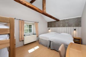 A bed or beds in a room at Hotel Aux Ecuries De La Reine