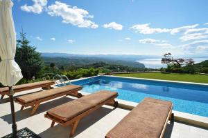 - une piscine avec bancs et une vue sur l'océan dans l'établissement Villa Bella Vista - Seaview Holiday Home, à Rukavac