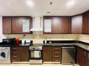 a kitchen with wooden cabinets and a stove top oven at Beautiful apartment with amazing sea views in Dubai