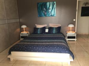 een slaapkamer met een groot bed met 2 lampen bij Bouzigues Suite Parentale Étang de Thau in Bouzigues