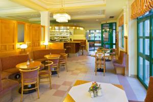 a restaurant with tables and chairs and a bar at Motel Baden in Baden