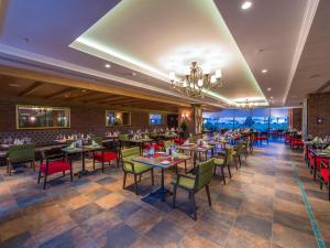 a restaurant with tables and chairs and a chandelier at Elite World Istanbul Florya in Istanbul