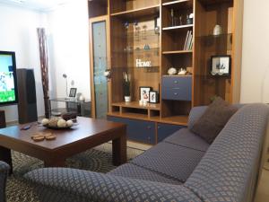 a living room with a blue couch and a table at Lilia's House at Trikala in Tríkala