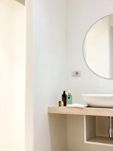 a bathroom with a sink, mirror, and toilet at Hotel Moresco in Santa Teresa Gallura