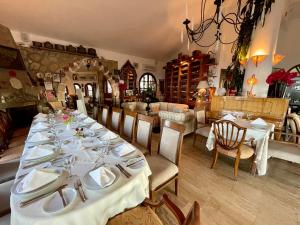 una sala da pranzo con un lungo tavolo e piatti bianchi di Bellapais Gardens a Kyrenia
