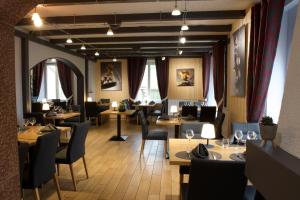 restauracja ze stołami, krzesłami i oknami w obiekcie Hotel Restaurant Du Haut Du Roc w mieście Basse-sur-le-Rupt