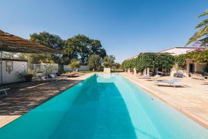 uma piscina com água azul num resort em HelloApulia Villa Barbara em Monopoli