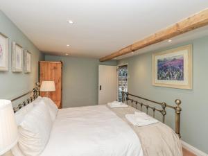 ein Schlafzimmer mit einem großen Bett mit weißer Bettwäsche in der Unterkunft Rose Cottage in Penrith
