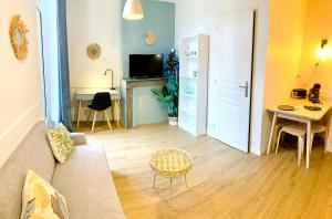 uma sala de estar com um sofá e uma mesa em LE DUMON 2 - T2 avec GARAGE - TERRASSE - WiFi - Gare à 200m em Agen